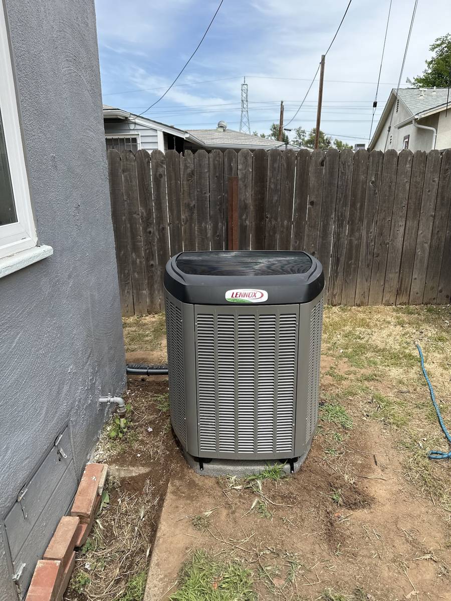 A serviced condenser unit along a fence line