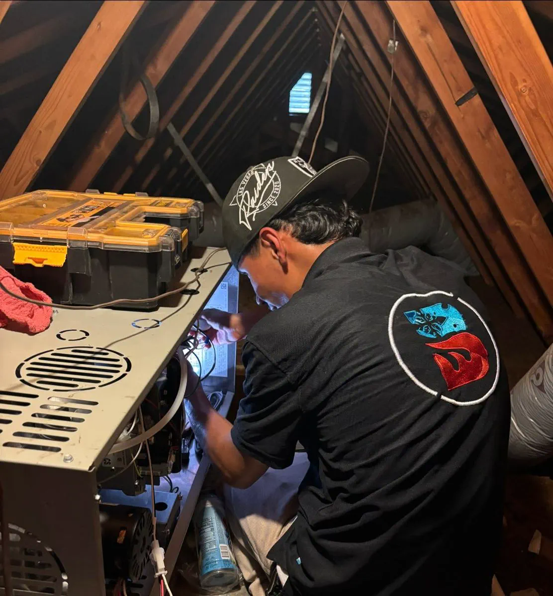A Barraza technician repairing a furnace in an attic