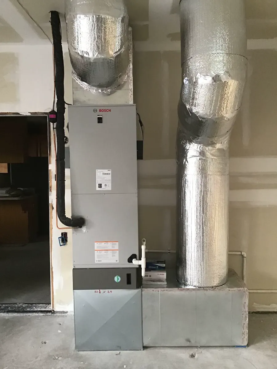 An air handler in a garage with insulated supply ducts