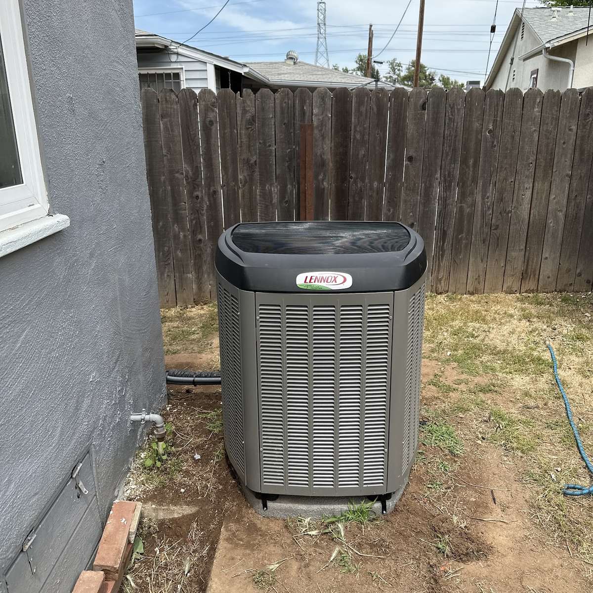 A serviced condenser unit at the side of a Sacramento home