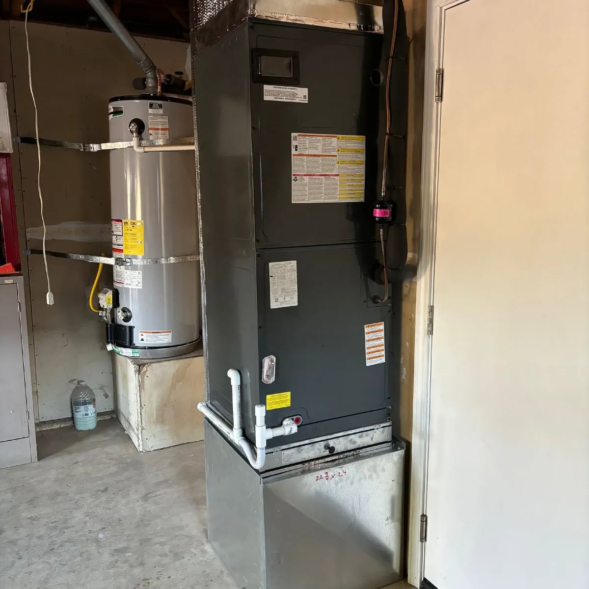 A new furnace and air handler installed cleanly in a garage